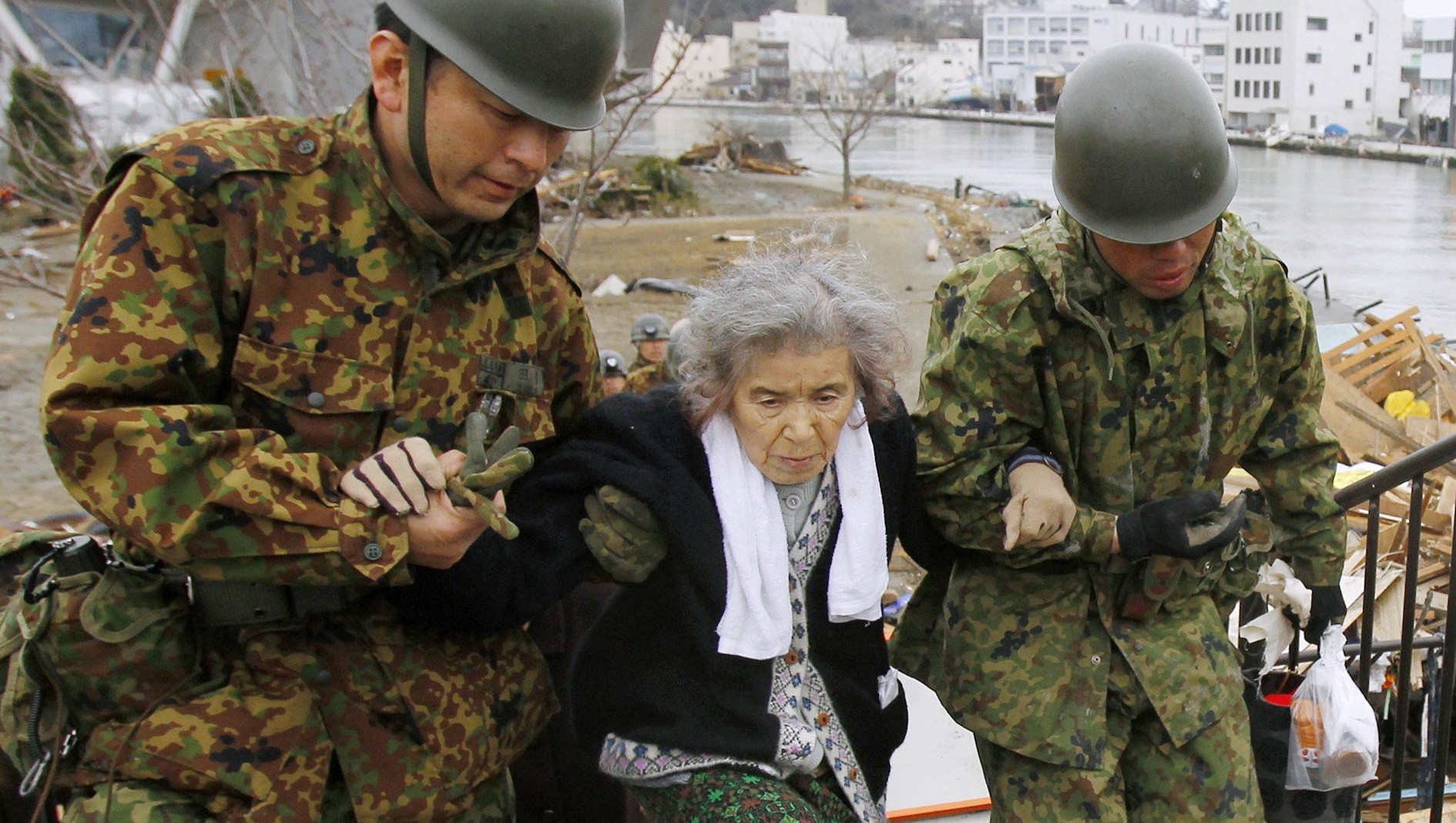 Vojaci pomáhajú Japonke, ktorá v dôsledku zemetrasenia prišla o strechu nad hlavou